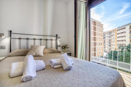 ein Schlafzimmer mit einem Bett mit Kissen und einem großen Fenster in der Unterkunft Fleming, cómodo apartamento junto Mezquita y Judería in Córdoba