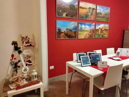 una camera con tavolo bianco e parete rossa di Colori Del Salento a Cellino San Marco