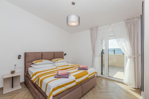 ein Schlafzimmer mit einem großen Bett und einem Balkon in der Unterkunft Holiday house VILLA ANDRO in Pinezici