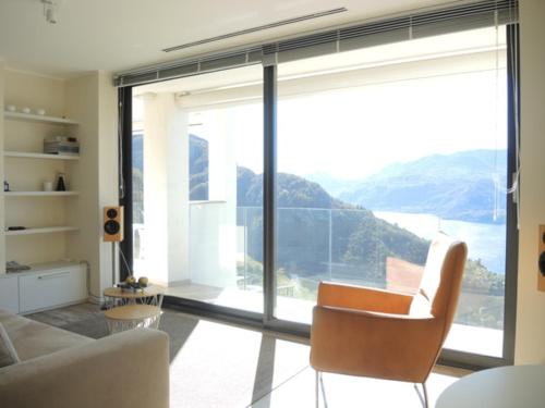 a living room with a couch and a large window at Italian Heaven in Perledo