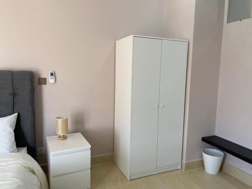a bedroom with a white cabinet next to a bed at TARA 58 in Krong Poi Pet