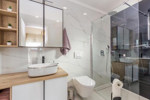 uma casa de banho com um WC e uma cabina de duche em vidro. em Holiday house VILLA ANDRO em Pinezici