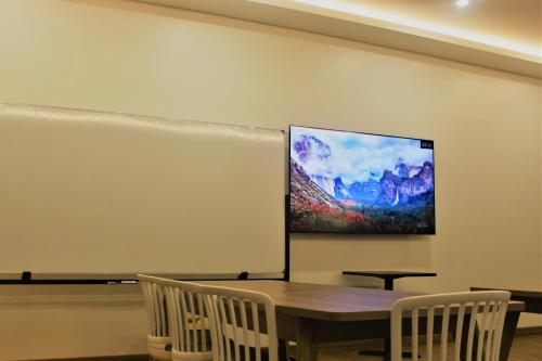 a conference room with a table and a screen at Treehouse Suites - Boutique Serviced Apartment in Jakarta