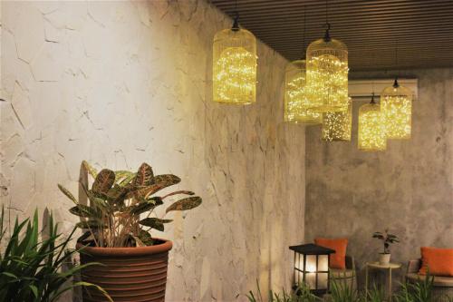 a room with three lights and a potted plant at Treehouse Suites - Boutique Serviced Apartment in Jakarta