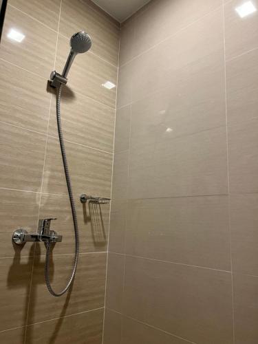 y baño con ducha con cabezal de ducha. en Uptown Parksuites II, en Manila