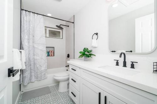 a white bathroom with a sink and a toilet at Beautiful Home North Shore Paradise Steps to Beach Unit A in Hauula