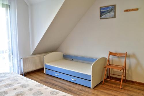 uma cama e uma cadeira num quarto em Trzy Siostry em Stronie Śląskie