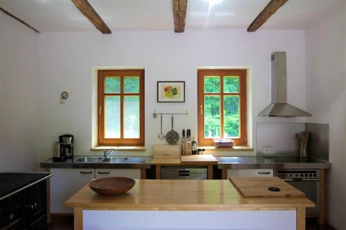 a kitchen with a wooden counter top and some windows at Kellerstöckl - Am Vierkanthof 