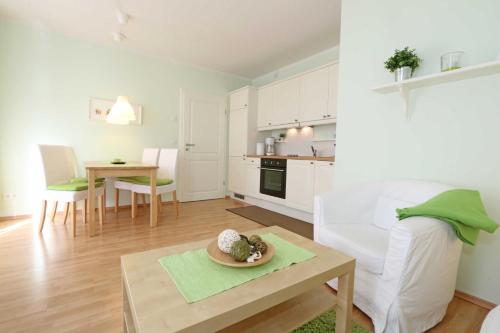 a living room with a white couch and a table at Villa Lena - Ferienwohnung 03 mit Balkon in Ostseebad Sellin