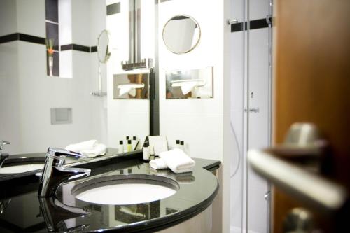 a bathroom with a sink and a mirror at Crowne Plaza Brussels Airport by IHG in Zaventem