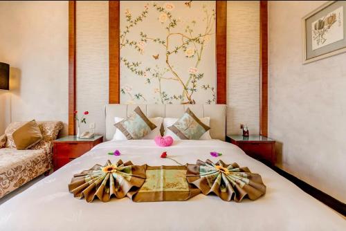 a bedroom with a large white bed with bows on it at Guangzhou Nuomo International Hotel-Canton Fair Free Shuttle Bus in Guangzhou