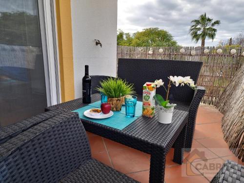 a table with a bottle of wine and food on a patio at Pé na Areia in Cabanas de Tavira