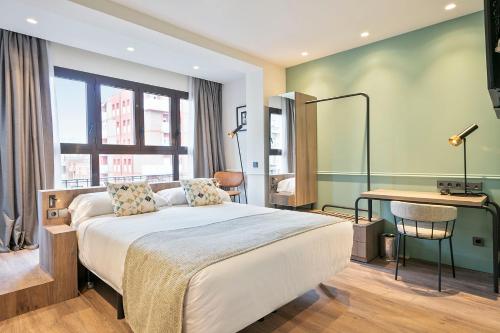 1 dormitorio con cama, escritorio y ventana en Hotel Via Augusta en Barcelona