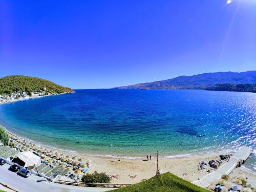 a view of a beach with a group of chairs at New Aegli Resort Hotel in Poros