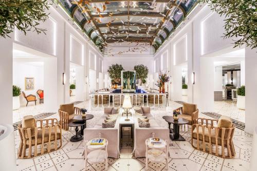a lobby with tables and chairs and a ceiling at Fairmont La Marina Rabat Sale Hotel in Rabat