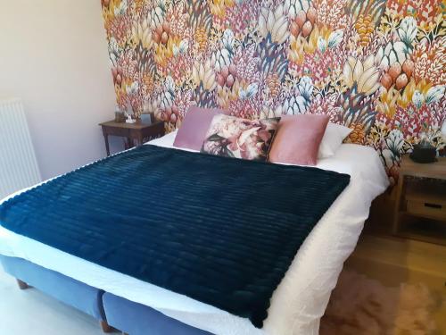 um quarto com uma cama com papel de parede floral em B&B Caprice d'Epices em Francorchamps