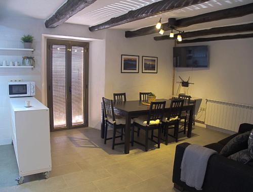 a kitchen and dining room with a table and chairs at Cal Moliner De Castelladral in Castelladral