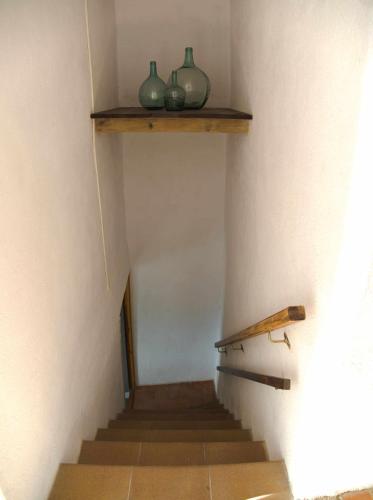 a staircase with two green vases on a shelf at Cal Moliner De Castelladral in Castelladral