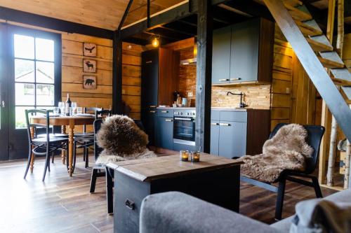 a kitchen and dining room with a table and chairs at La cabane du cerf et son sauna in Attre