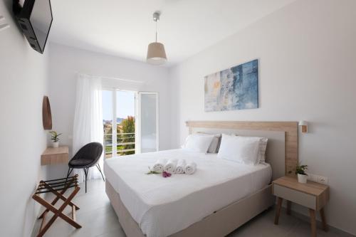 a white bedroom with a bed with two towels on it at spiti lithero in Arillas