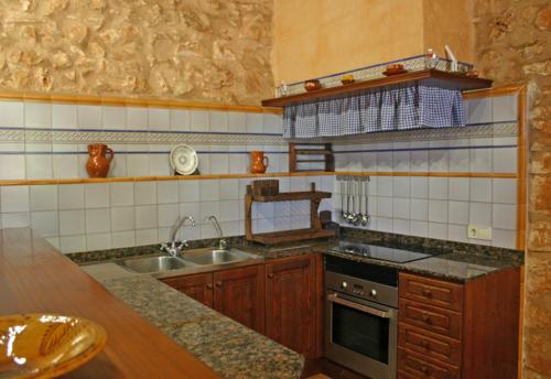 a kitchen with a sink and a stove at Son Fumat in Es Llombards