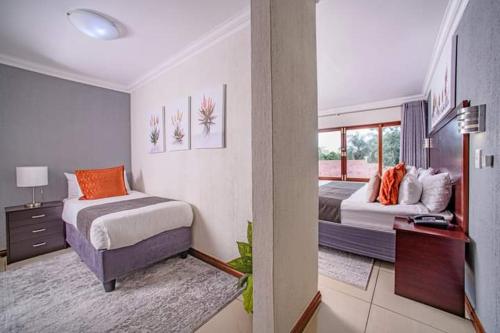 Habitación de hotel con 2 camas y ventana en Khayalami Hotel - Mbombela, en Nelspruit