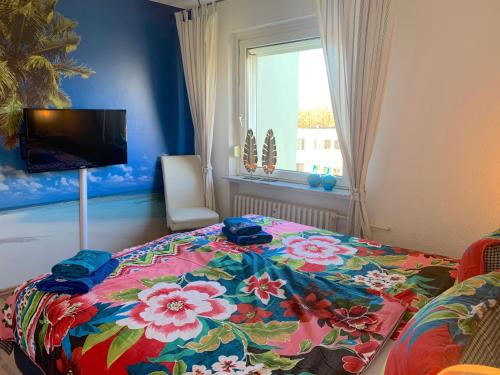 Bremen Ferienwohnung في بريمين: غرفة نوم مع سرير مع بطانية مزهرة عليه