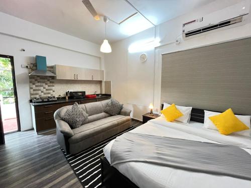 a hotel room with a bed and a couch at BedChambers Serviced Apartment, Jubilee Hills in Hyderabad