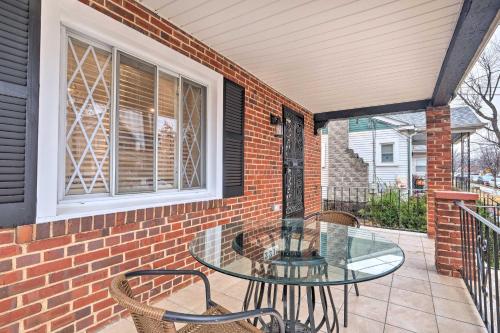a patio with a glass table and chairs on a brick wall at Washington, DC, Vacation Rental By Arboretum in Washington, D.C.