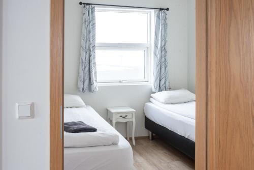 a small bedroom with two beds and a window at The Holiday Houses by Stay in Iceland in Kirkjubæjarklaustur