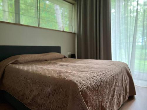 a bed in a bedroom with a large window at Jurmala Lux Apartments - Seaside in Jūrmala