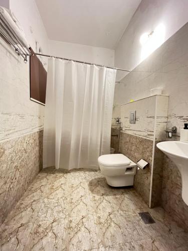 a bathroom with a toilet and a sink at BedChambers Serviced Apartment, Jubilee Hills in Hyderabad