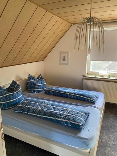two beds with blue pillows in a room at Nordwind Sjut in Warnow