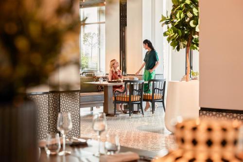 a woman standing in front of a table in a restaurant at Fairmont La Marina Rabat Sale Hotel in Rabat