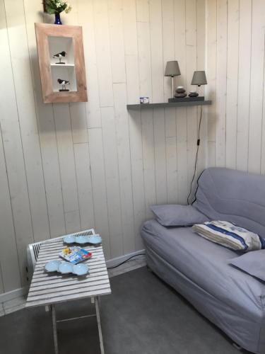 un soggiorno con un divano e un tavolo di Chambre La Poulpiquet ad Ars-en-Ré