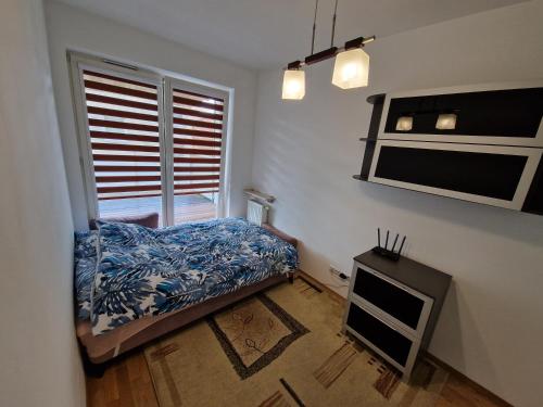 Habitación pequeña con cama y ventana en Kameralna Głębocka en Varsovia