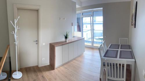 eine Küche mit einem Schreibtisch und einen Flur mit einer Tür in der Unterkunft Apartamentai Muziejaus g. in Birštonas
