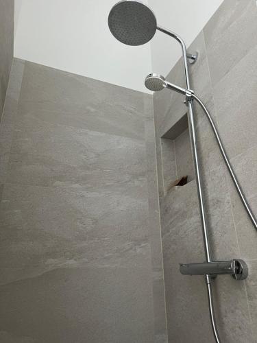 y baño con ducha con cabezal de ducha. en Apartamentai Muziejaus g., en Birštonas