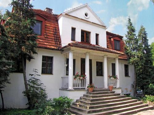 a white house with stairs in front of it at Dwór Jeziory Wielkie in Jeziory Wielkie