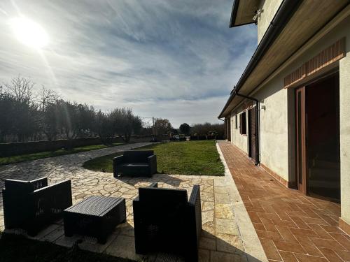 a patio with a group of chairs and a building at agriturismo villa amerina in Corchiano