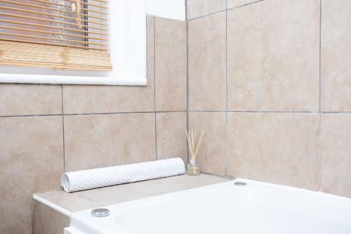 a bathroom with a white tub and a sink at ST MARGARETS - Spacious Home, High Speed Wi-Fi, Free Parking, Garden in Swindon