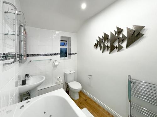 a white bathroom with a sink and a toilet at SHRIVENHAM - Spacious Home, High Speed Wi-Fi, Free Parking, Garden in Swindon