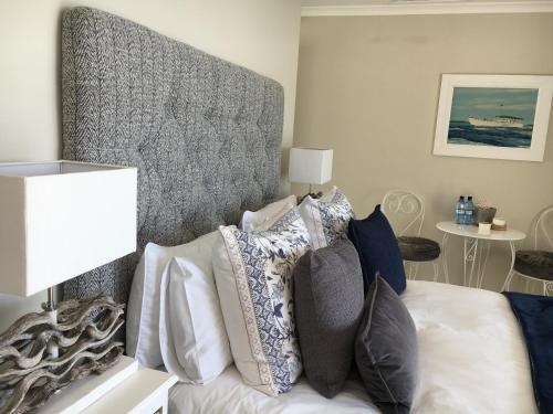 a bedroom with a bed with pillows on it at Seaforth Suite in Simonʼs Town