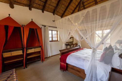 a bedroom with two beds and a crib at Jembisa Bush Home in Melkrivier