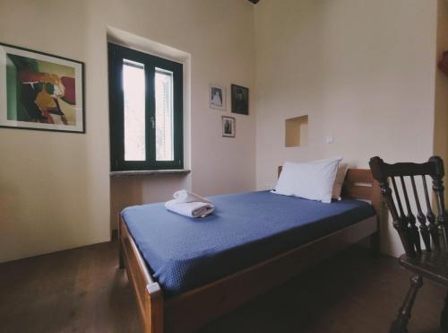 - une chambre avec un lit doté de draps bleus et une fenêtre dans l'établissement Pure Nature House, à Andros