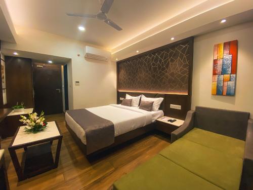 um quarto de hotel com uma cama e um sofá em Jardin Hotels em Indore