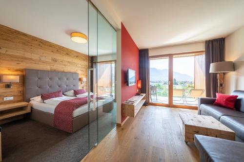 1 dormitorio con 1 cama y pared de cristal en Residence Der Heinrichshof, en Lagundo