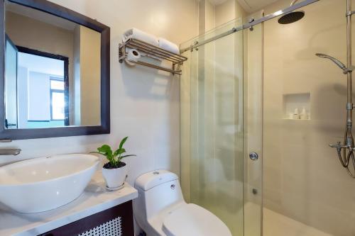 een badkamer met een toilet, een wastafel en een douche bij Hoi An Ivy Hotel in Hội An