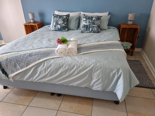 Una cama con dos pares de zapatillas. en La Maison on Vaal Bed and Breakfast, en Denysville