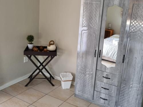 Dormitorio con puerta y mesa con cama en La Maison on Vaal Bed and Breakfast, en Denysville
